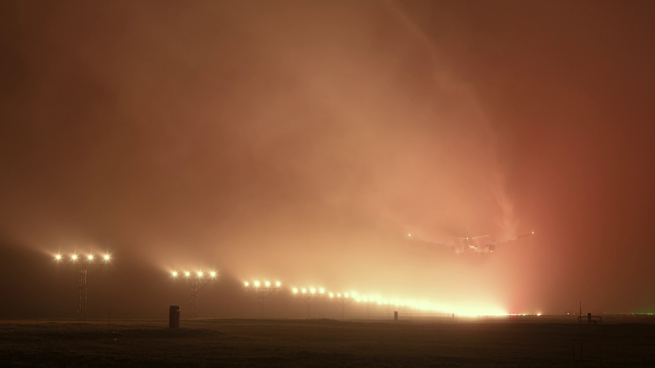 客机在雾蒙蒙的夜晚降落在机场视频下载
