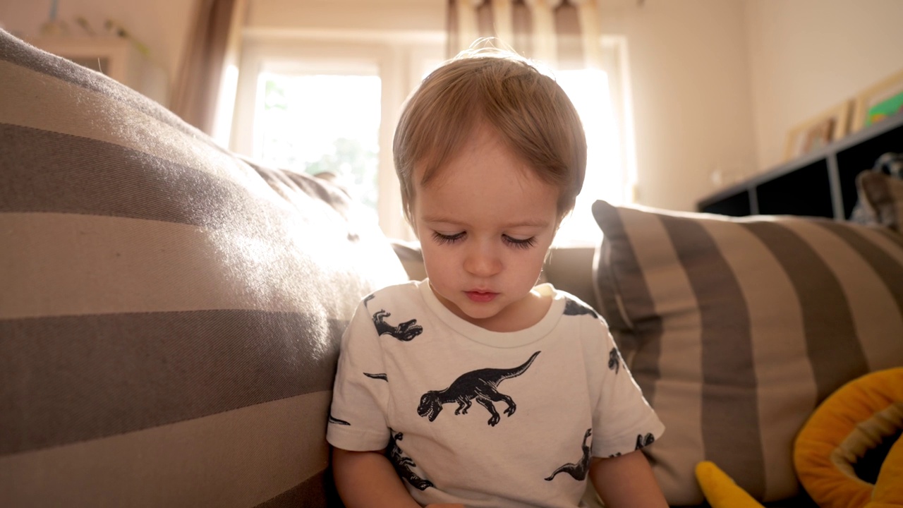 小男孩在沙发上玩玩具视频素材