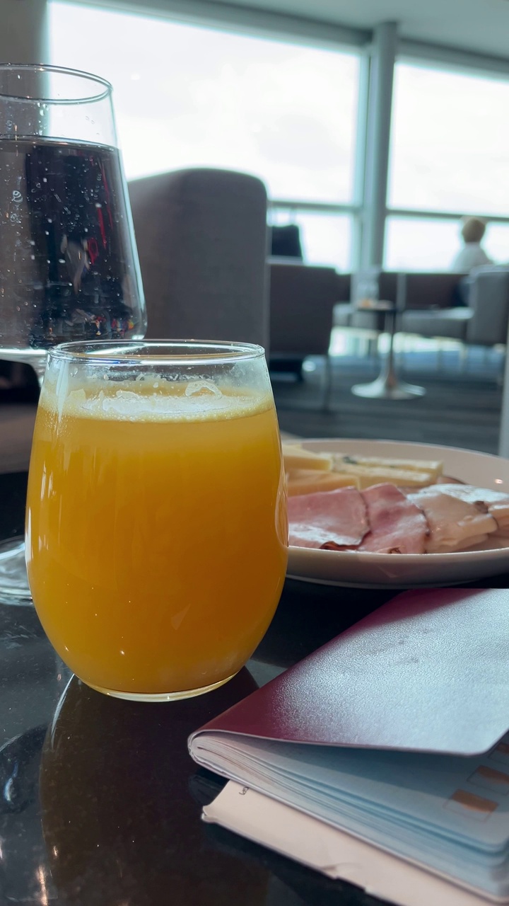 在机场的贵宾休息室享受豪华小吃熟食店:橙汁、苏打水和一桌火腿和各种奶酪。视频下载