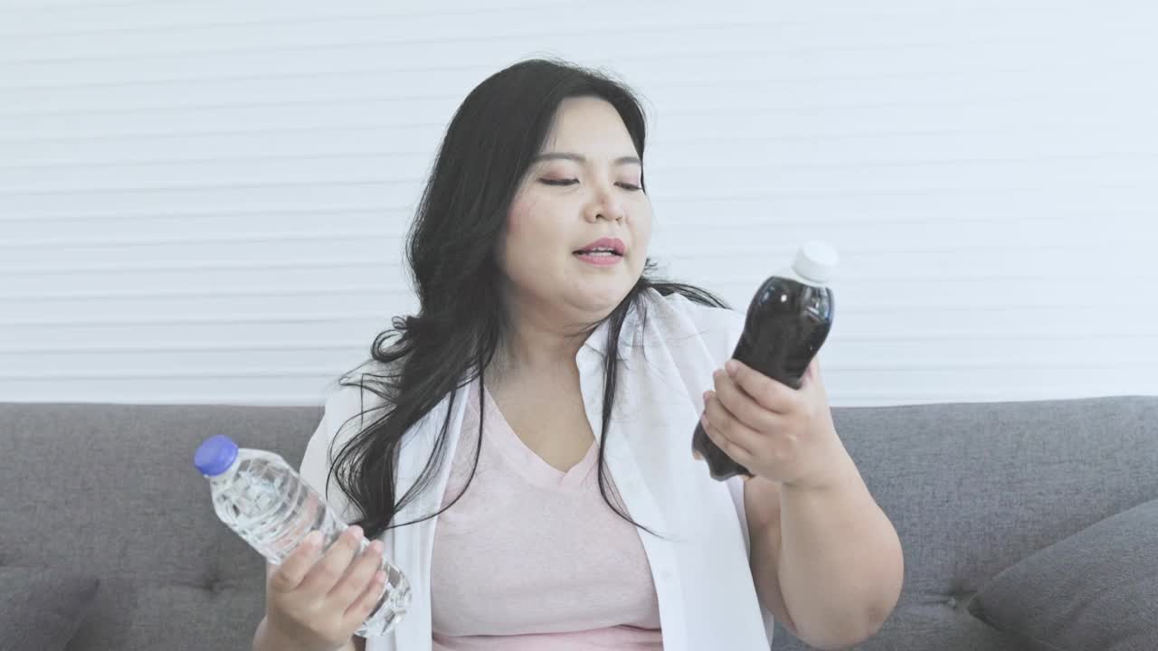 胖乎乎的女人选择可乐或水视频下载