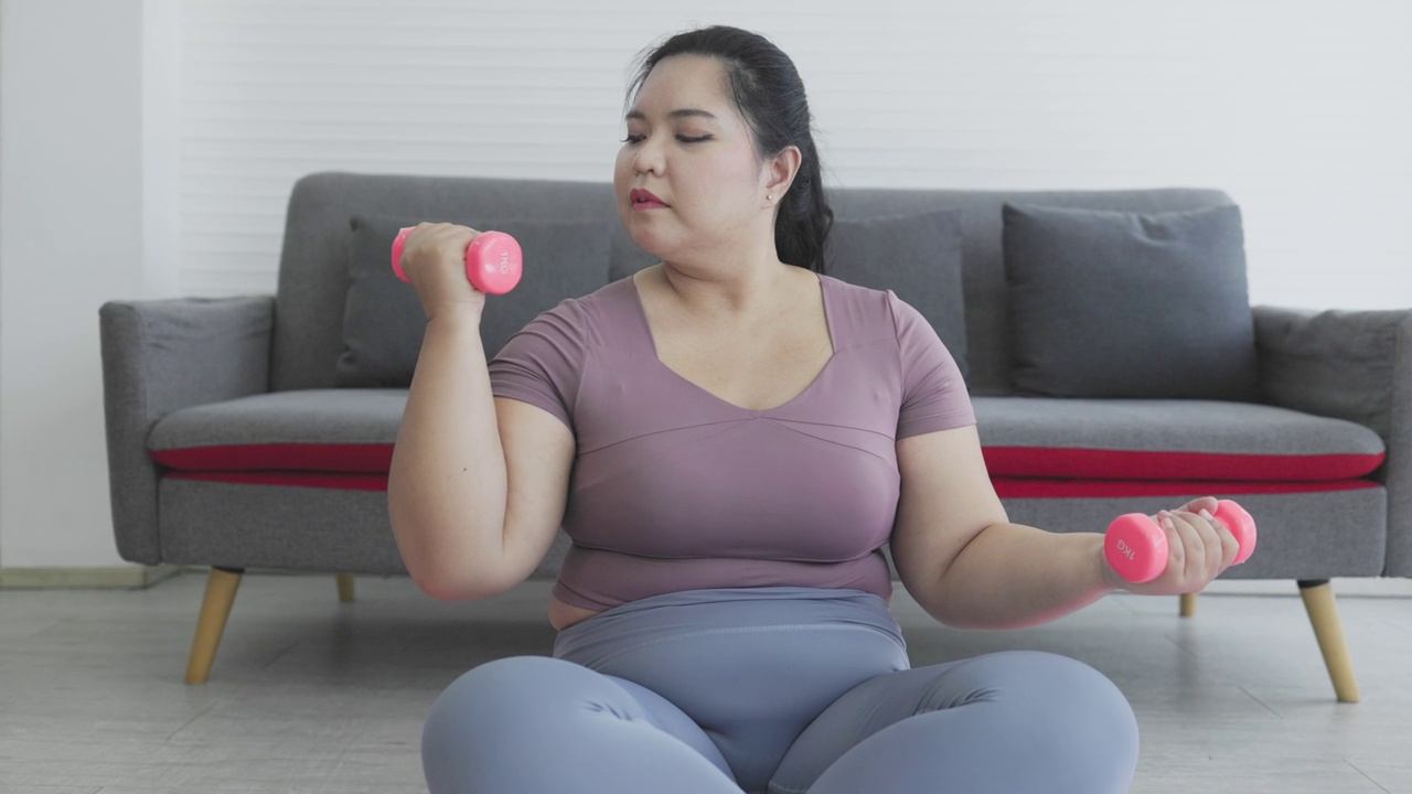 胖乎乎的女人在用哑铃锻炼视频素材