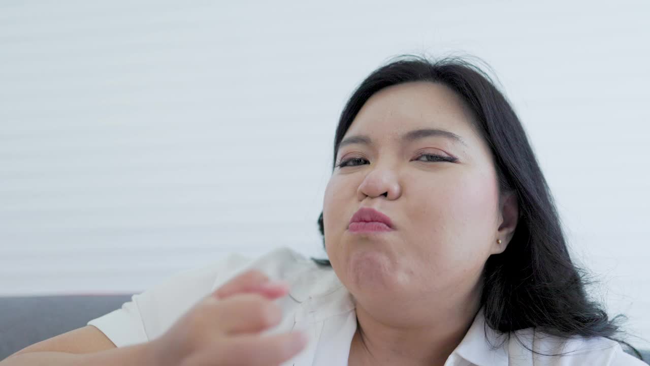 胖乎乎的亚洲女人开心地吃着土豆零食视频下载