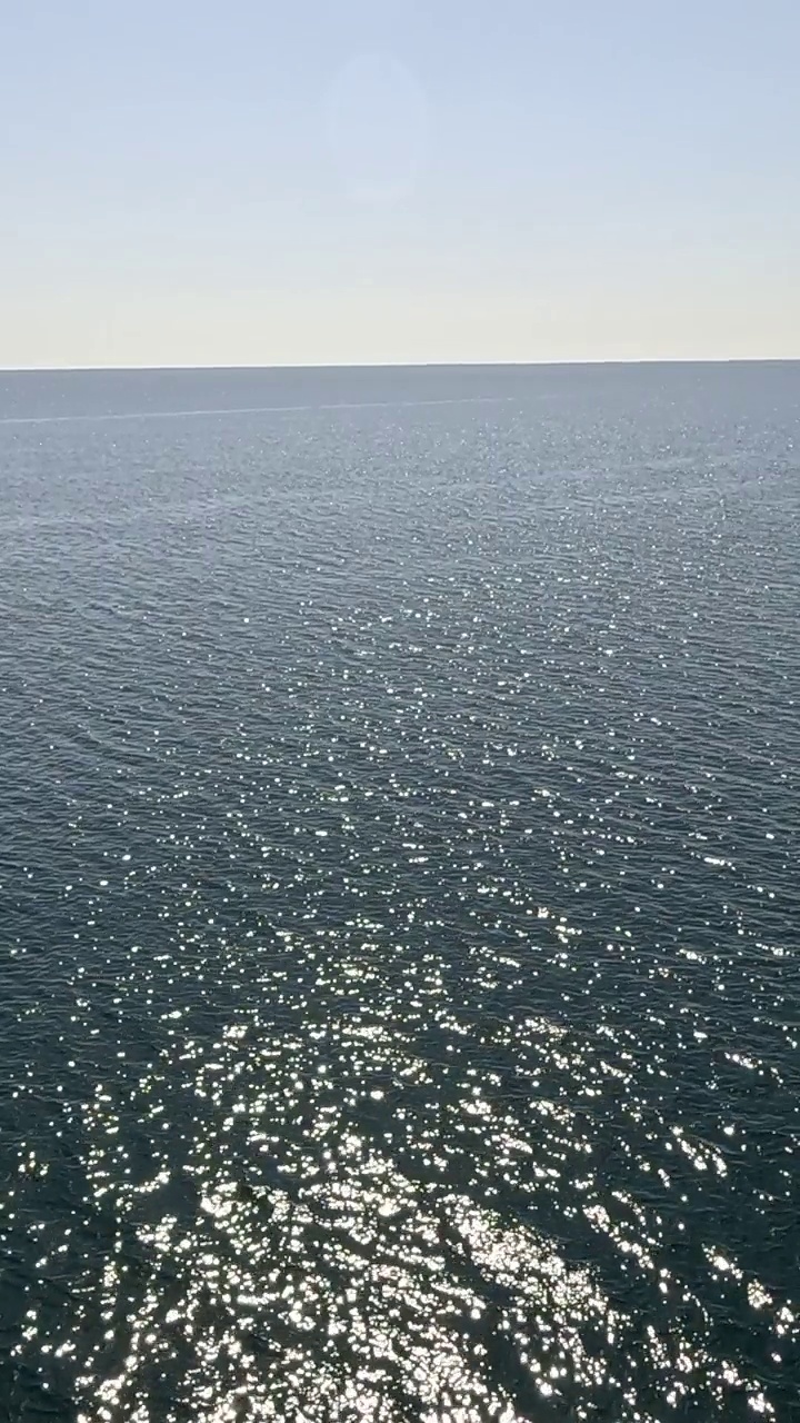 海水表面。从皮艇的低角度看，相机飞过清澈的海水。没有人。假日休闲概念。抽象航海夏季海洋自然。缓慢的运动。关闭了。垂直视频视频下载