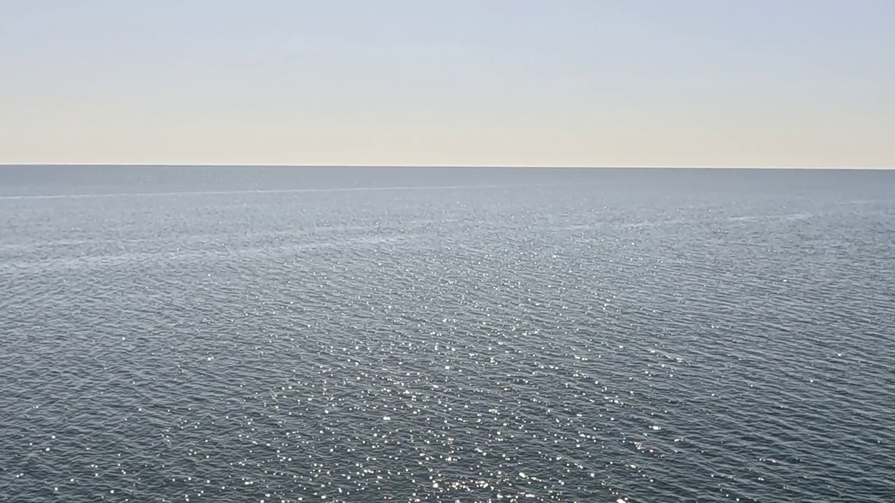 海水表面。鸟瞰清澈湛蓝的海水。太阳眩光。抽象航海夏季海洋自然。度假、度假、旅游的概念。没有人。缓慢的运动。天气和气候变化视频下载