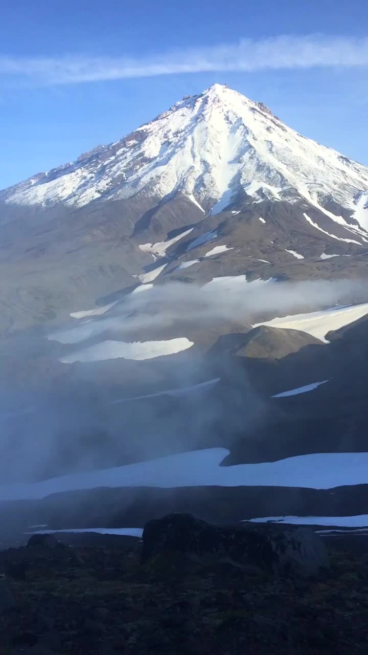 Koryaksky火山的峰顶在云层上升起视频下载
