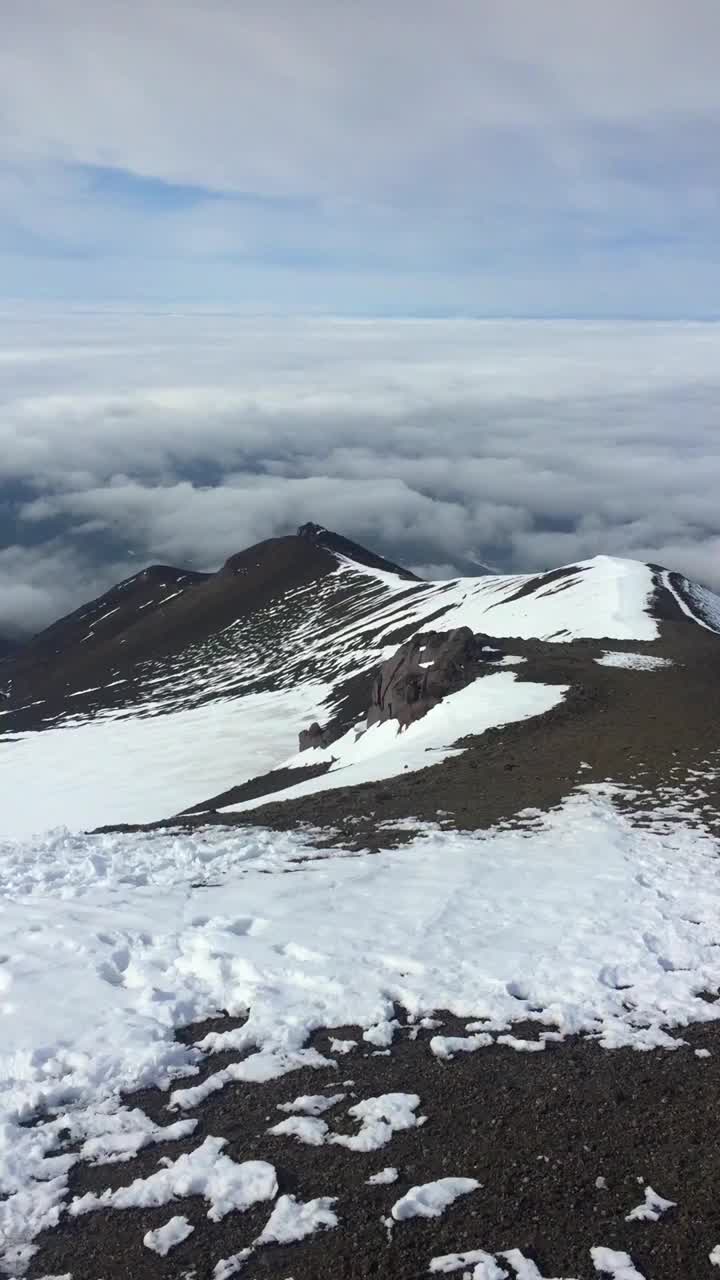 Koryaksky火山的峰顶在云层上升起视频下载