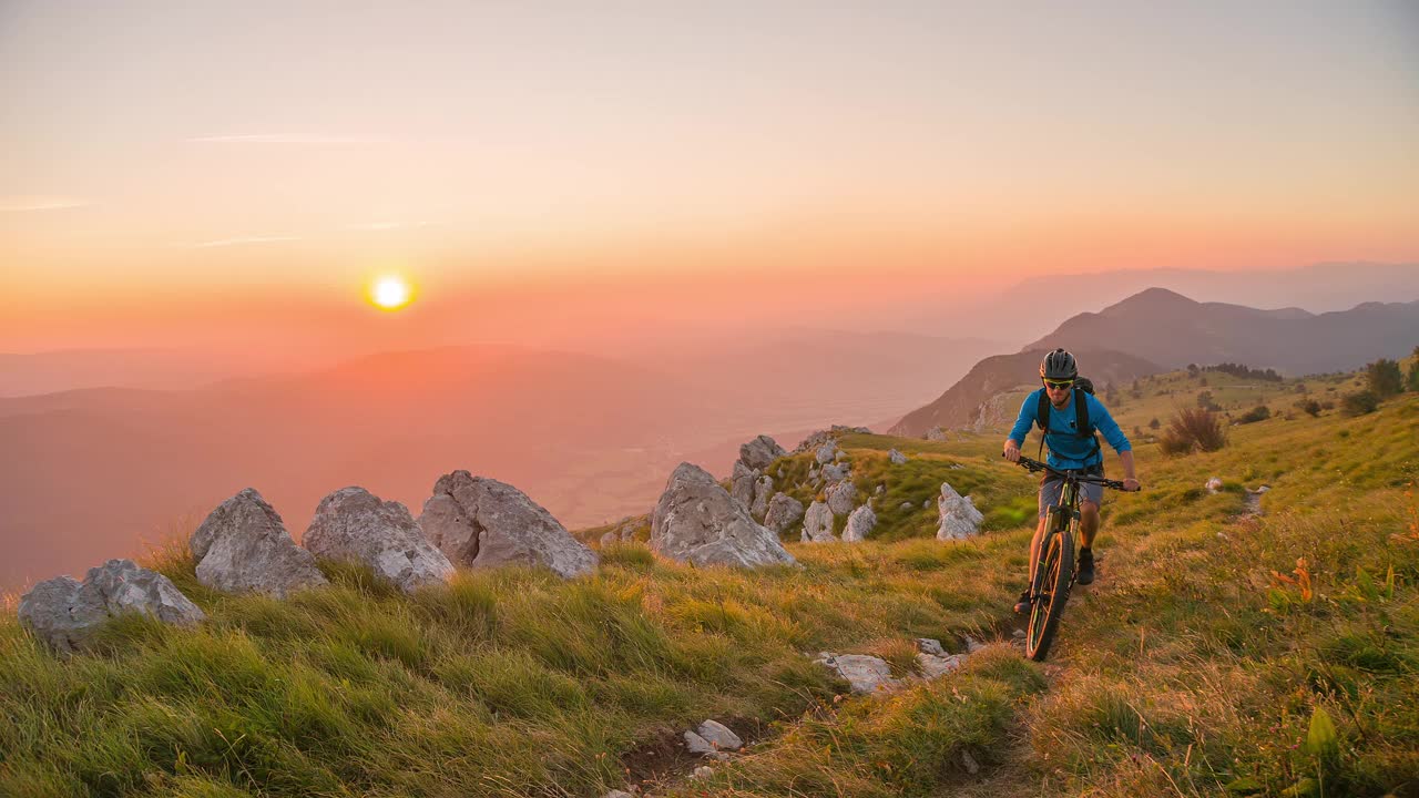 日落时分，骑山地自行车上山的男子视频下载