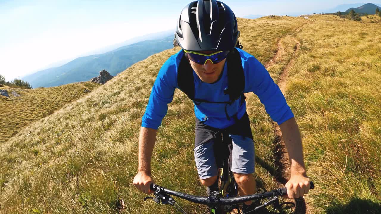 坚定的运动员骑山地自行车越野视频下载