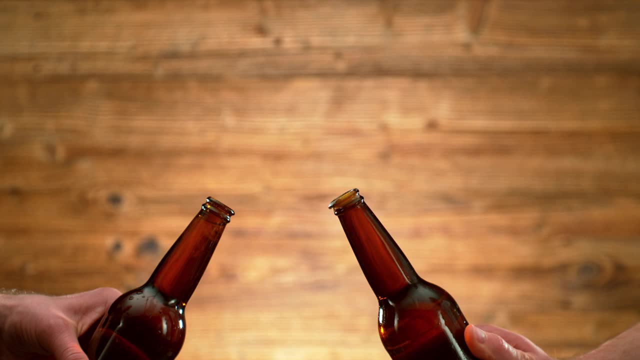 用啤酒瓶敬酒的超级慢动作，镜头移动视频下载