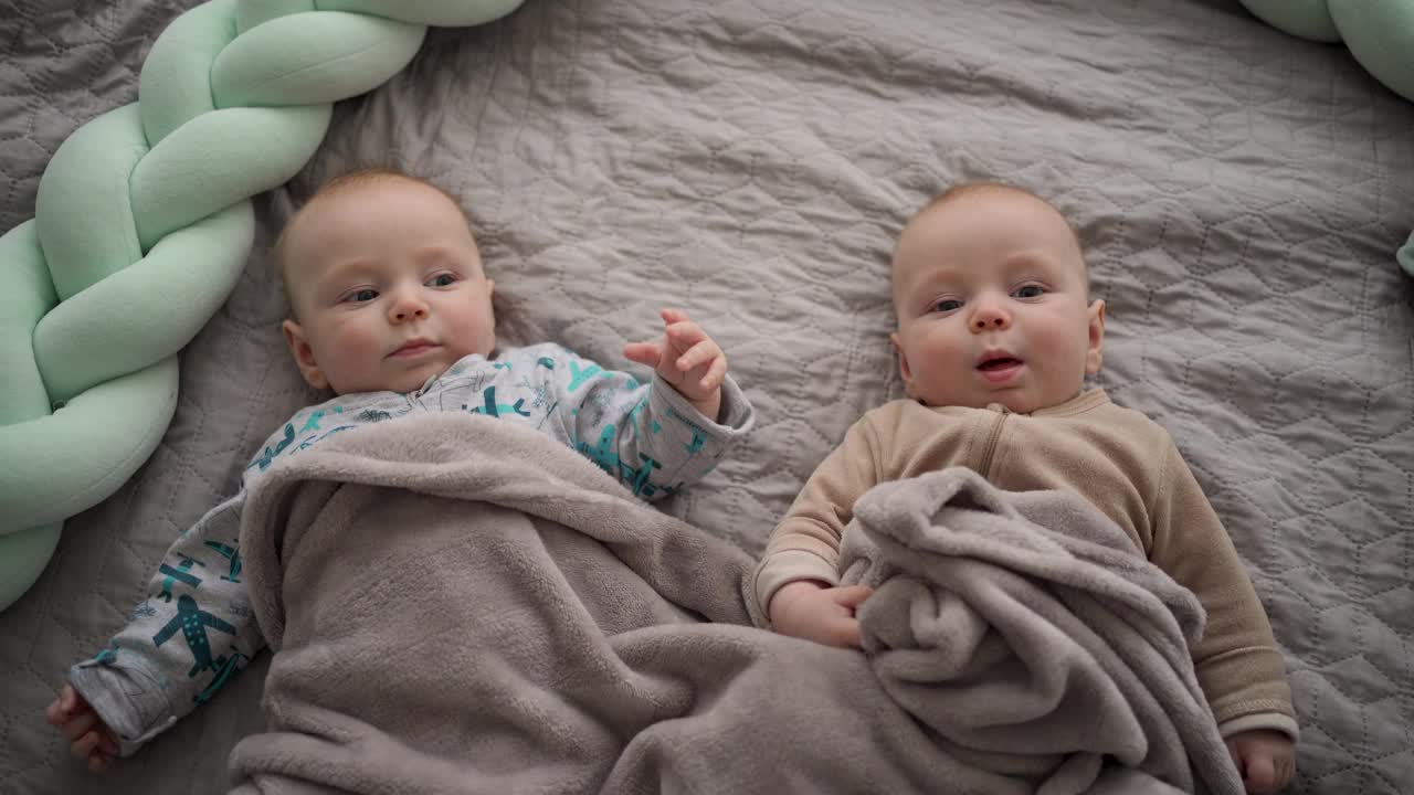 两个可爱的双胞胎宝宝在卧室的床上休息视频下载