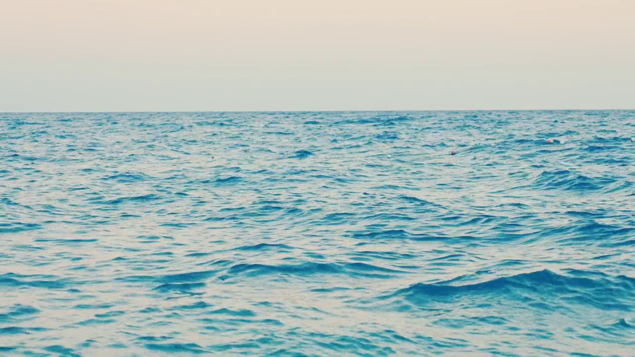 令人惊叹的4k海洋视频，有平坦的天空和小波浪。这段视频展示了夏季地中海美丽的日落。视频下载