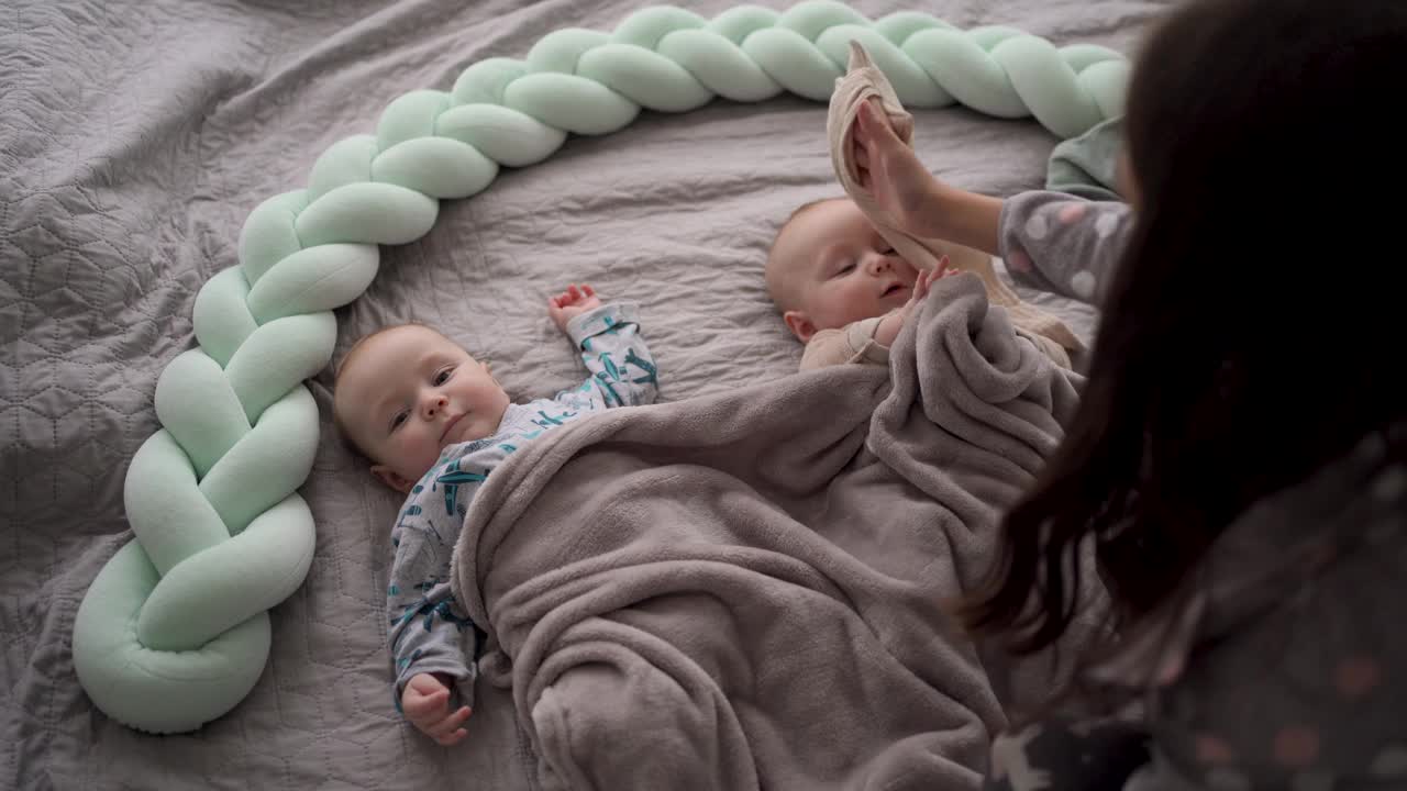 两个可爱的双胞胎宝宝在卧室的床上休息视频下载