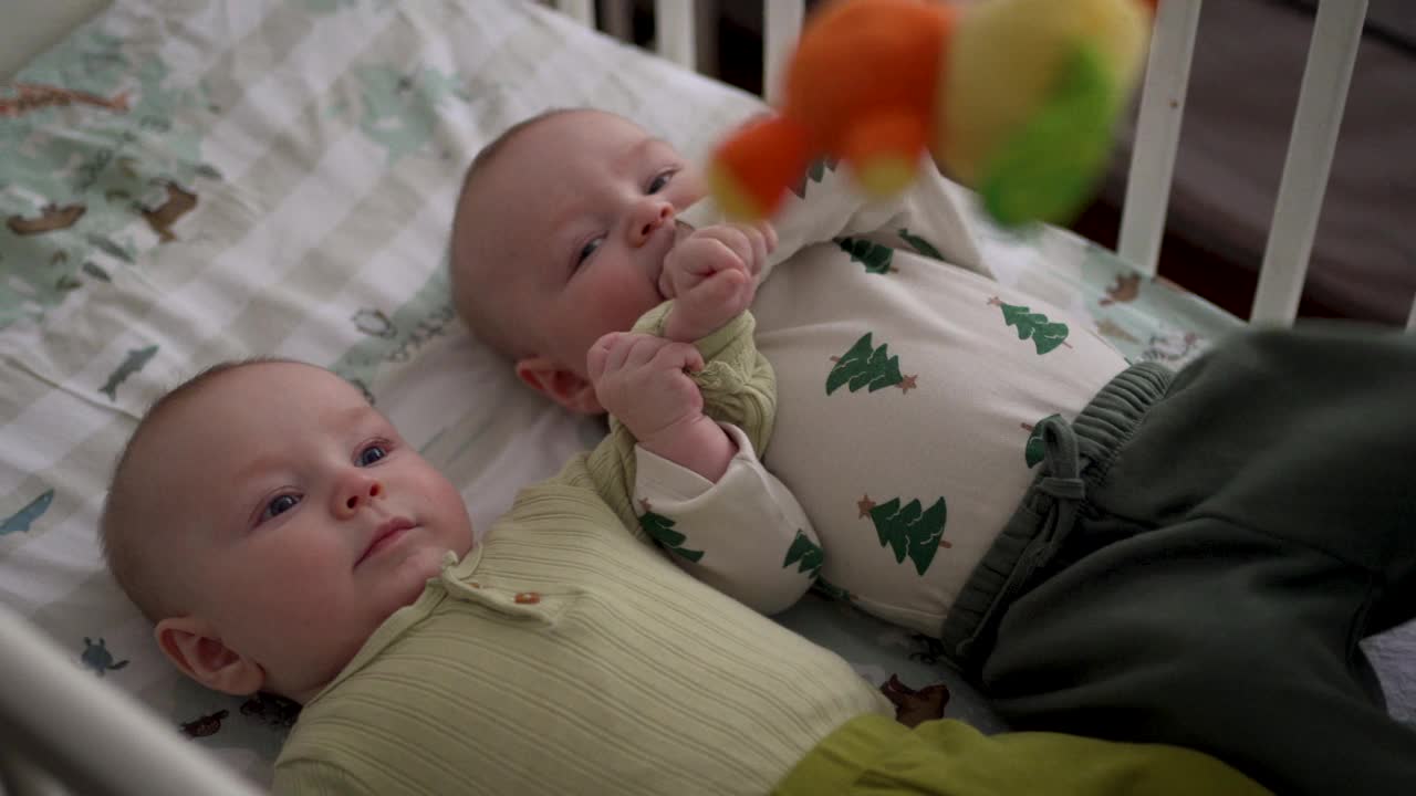 两个可爱的小男孩兄弟姐妹在家里的婴儿床上休息视频下载