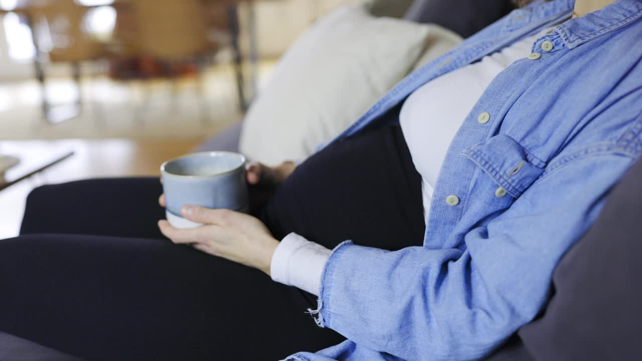 孕妇在家坐在沙发上喝咖啡视频下载