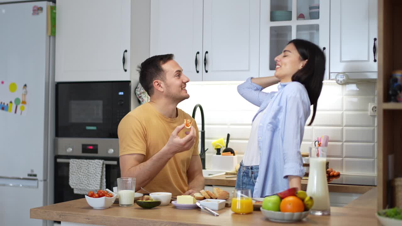 一对年轻的白人夫妇在厨房吃早餐的画像视频下载