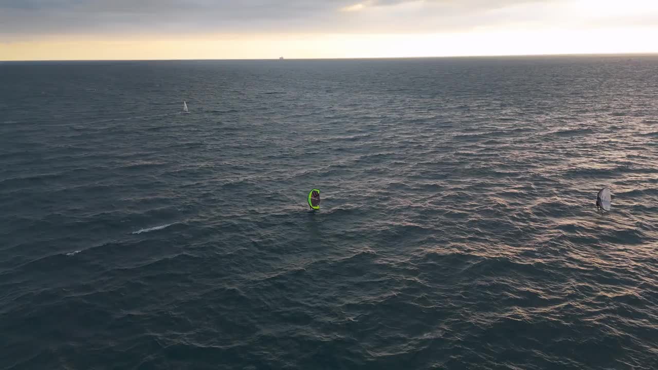 风筝冲浪滑翔在蓝色的海水热那亚海岸，意大利黄昏，宁静的海洋景象视频下载