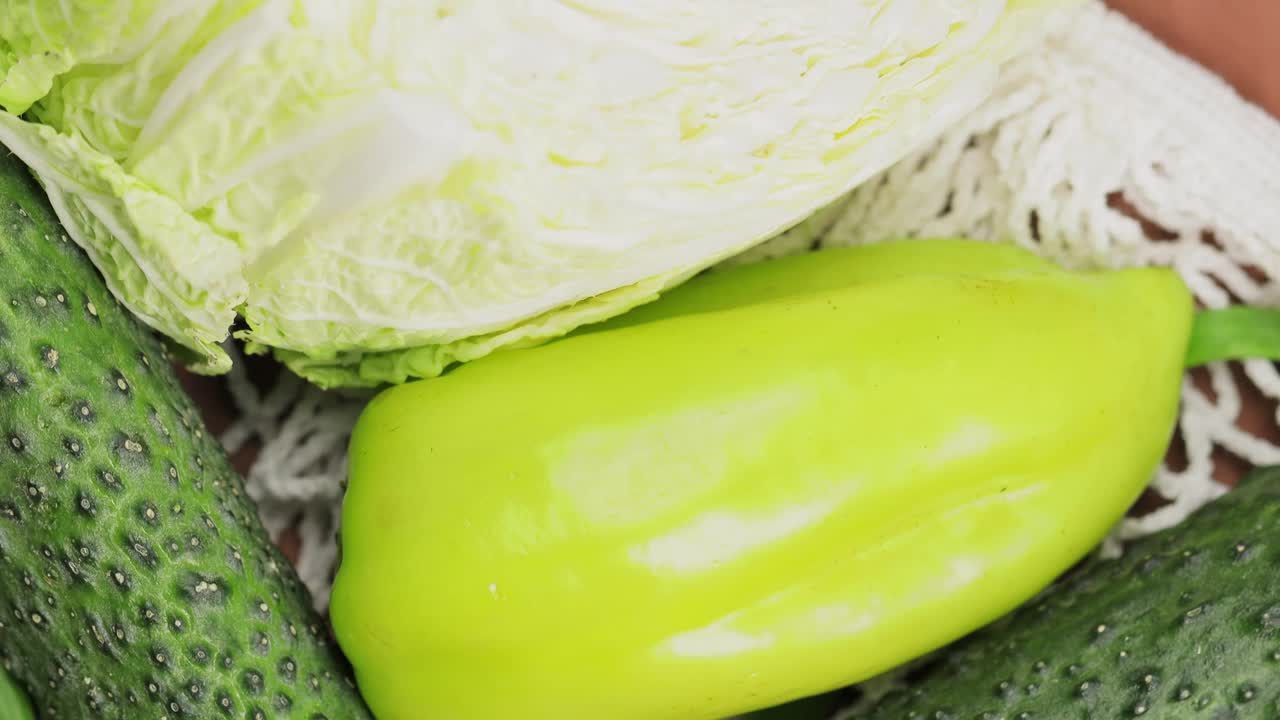 环保收获:新鲜的绿色蔬菜在白色绳袋视频下载