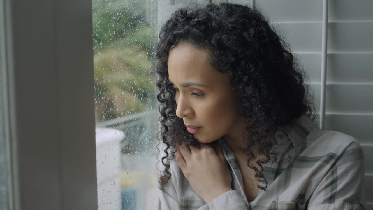 悲伤，女人和思考在下雨天压力与焦虑或抑郁在家的窗口。失意的年轻女性在心理健康方面望着窗外，在室内疲劳或失误视频下载