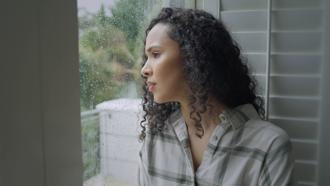 女人，思考和窗口抑郁的早晨下雨，焦虑或压力在家里。悲伤的年轻女性望着窗外的玻璃或雨，精神健康，疲劳或错误，在房子里疑惑视频下载