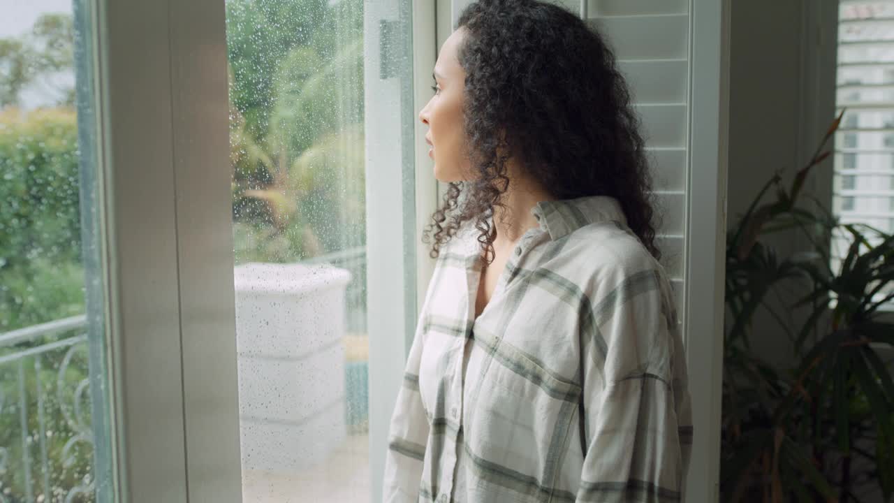 沮丧，女人和思考在下雨天压力与焦虑或抑郁在家的窗口。悲伤的年轻女性在心理健康方面看玻璃，在室内疲劳或错误视频下载