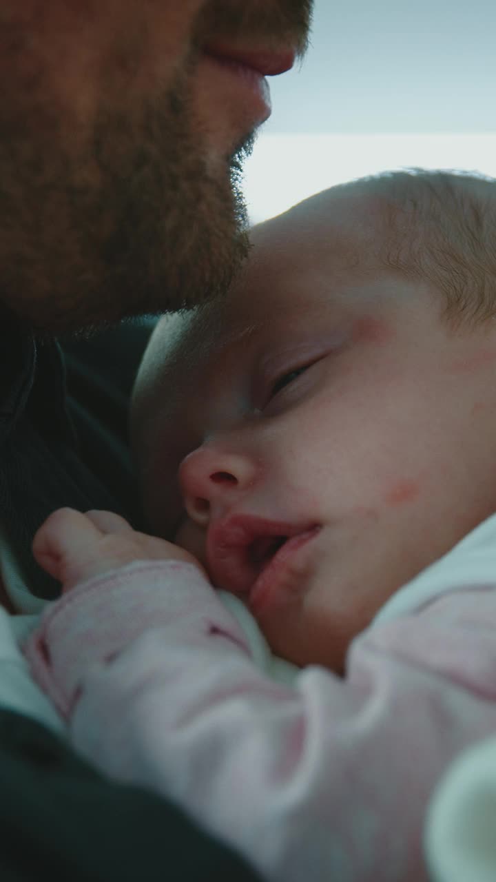 微笑的父亲和熟睡的婴儿在医院视频下载