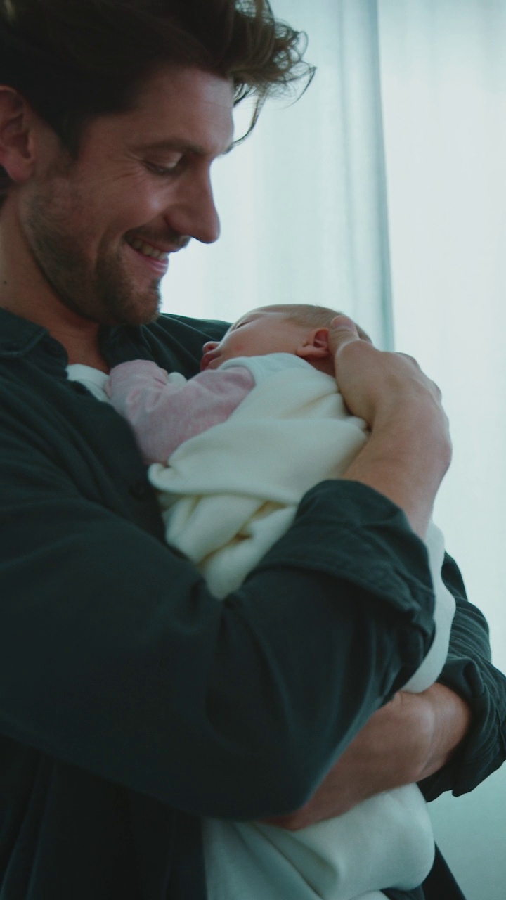 快乐的父亲在病房里抱着熟睡的新生儿视频下载
