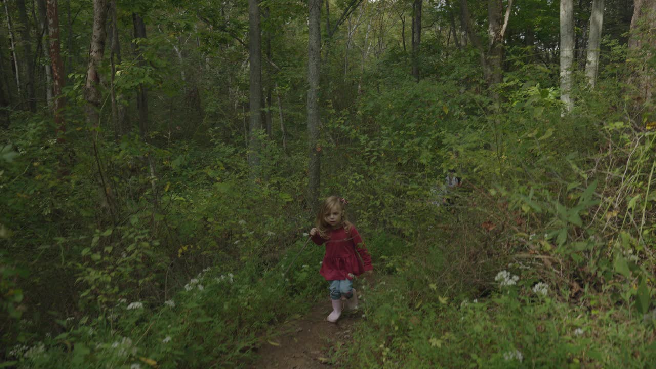 跟踪拍摄的微笑的女孩徒步旅行在森林/ Goshen，肯塔基州，美国视频下载