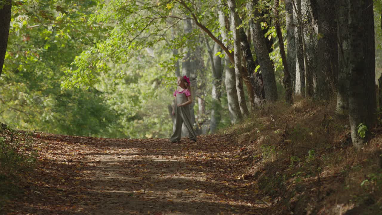 无忧无虑的女孩在森林小径上蹦蹦跳跳/美国肯塔基州Goshen视频下载