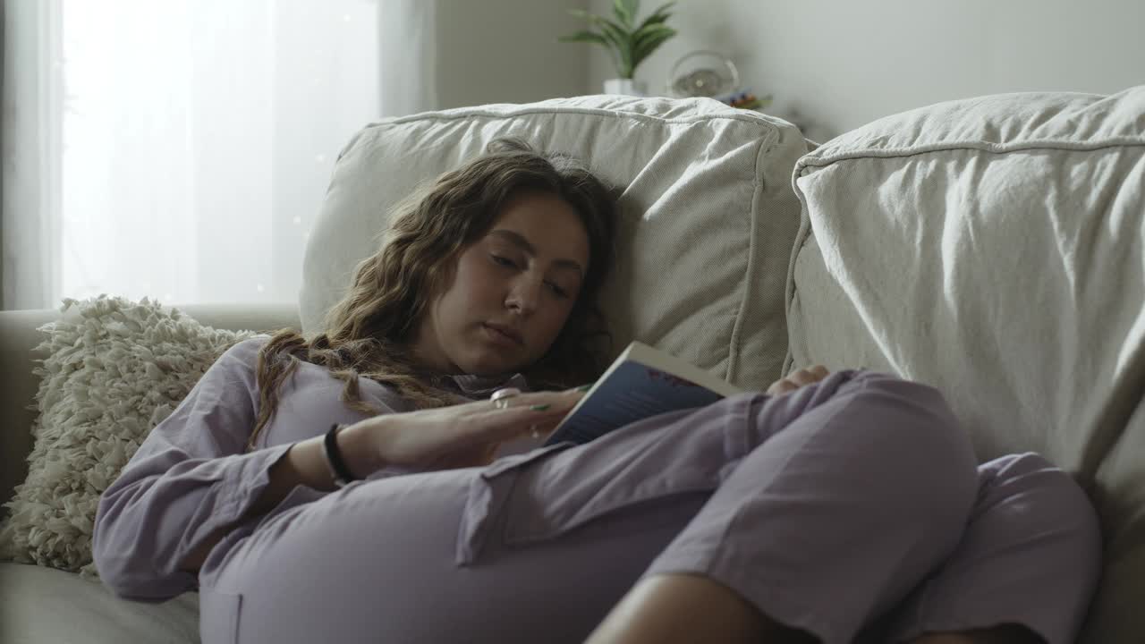 妇人躺在沙发上看书的特写/美国犹他州雪松山视频下载