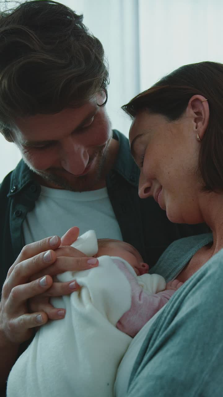 深情的男人亲吻抱着新生儿的女人视频下载