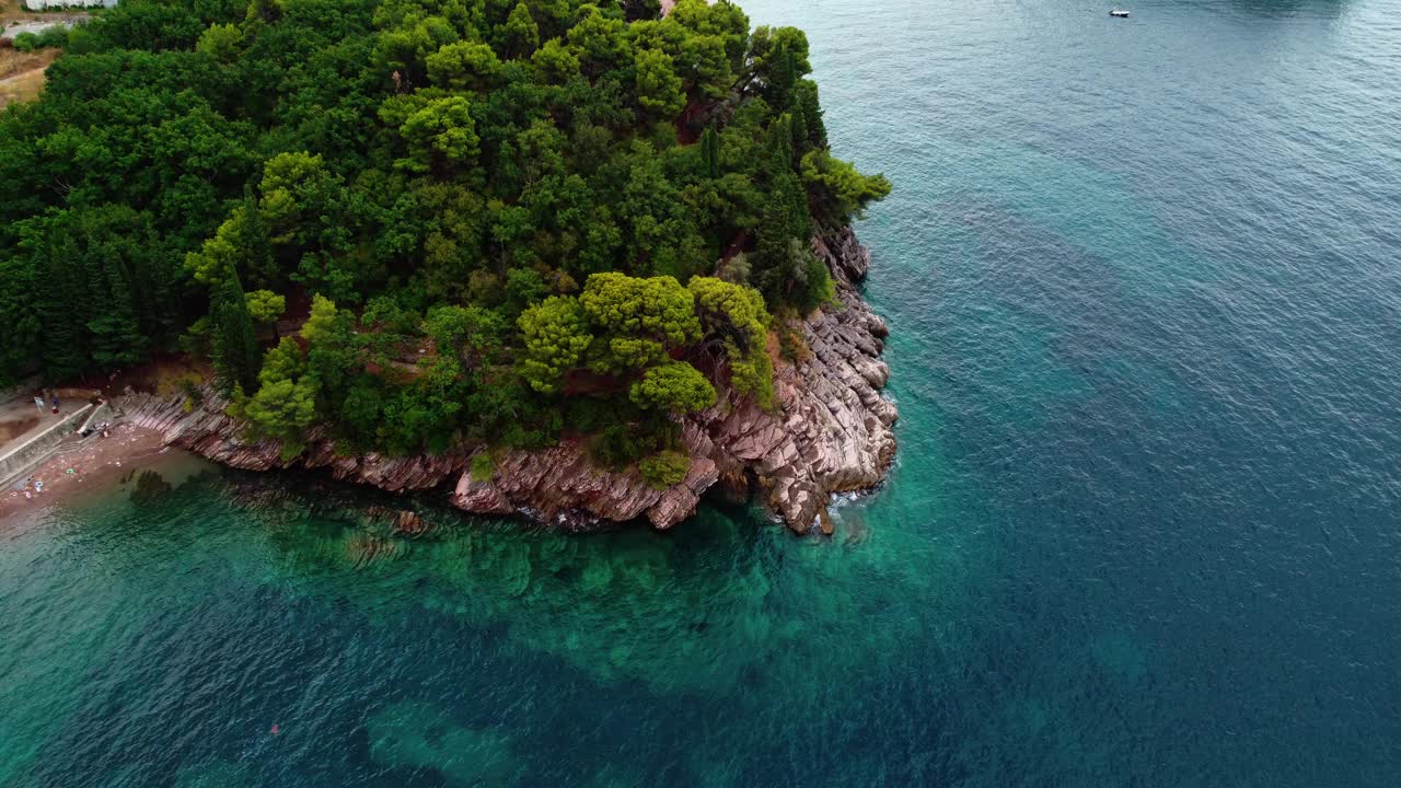鸟瞰美丽的自然景观，海岸线，透明的绿松石底和悬崖，典型的亚得里亚海叶植被。黑山，斯维蒂斯特凡岛为背景。视频下载