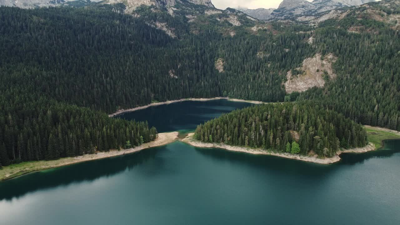 令人惊叹的空中无人机视图的Crno Jezero或黑湖，松树林和悬崖在杜米特国家公园，扎布利亚克，黑山。旅游，环境，大自然，放松。联合国教科文组织世界遗产视频下载