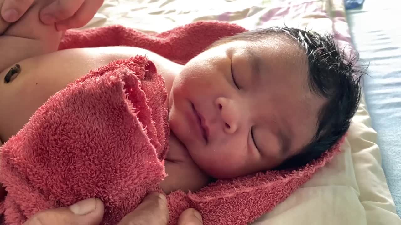 母亲在洗澡后给刚出生的婴儿涂抹婴儿乳霜视频下载