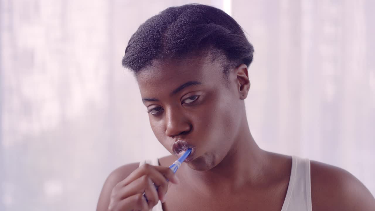 牙科、牙刷和刷牙与黑人妇女在浴室进行口腔卫生、晨间例行和清洁。牙膏，护理和健康的女孩的脸和嘴的化妆品和习惯视频下载