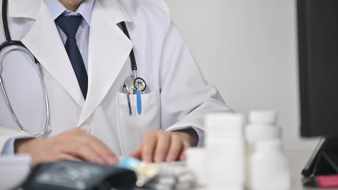 一位中年男医生正在用电脑进行远程医疗视频下载