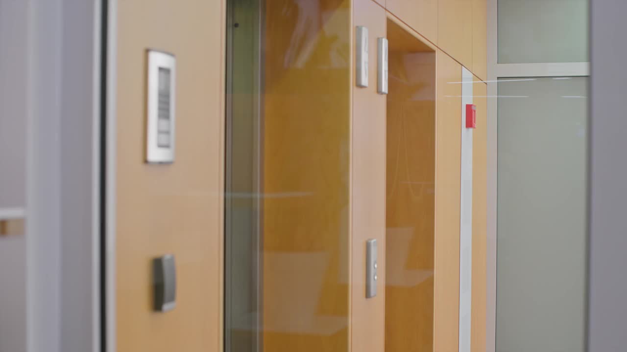 两个女人走出电梯，从办公室的玻璃门进来视频下载