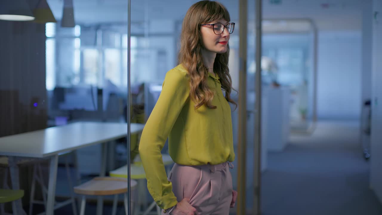 微笑的女人戴着眼镜，站在办公室的走廊里视频下载