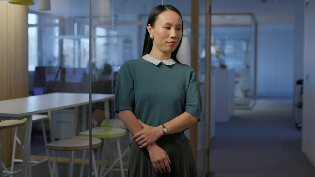 一个微笑的亚洲女人站在办公室走廊的肖像视频下载