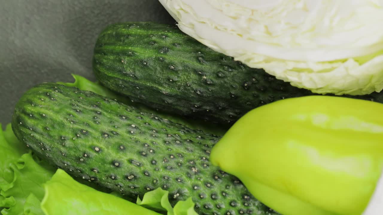 新鲜的绿色蔬菜:生菜，黄瓜，甜椒和卷心菜在白色绳袋，特写视频下载