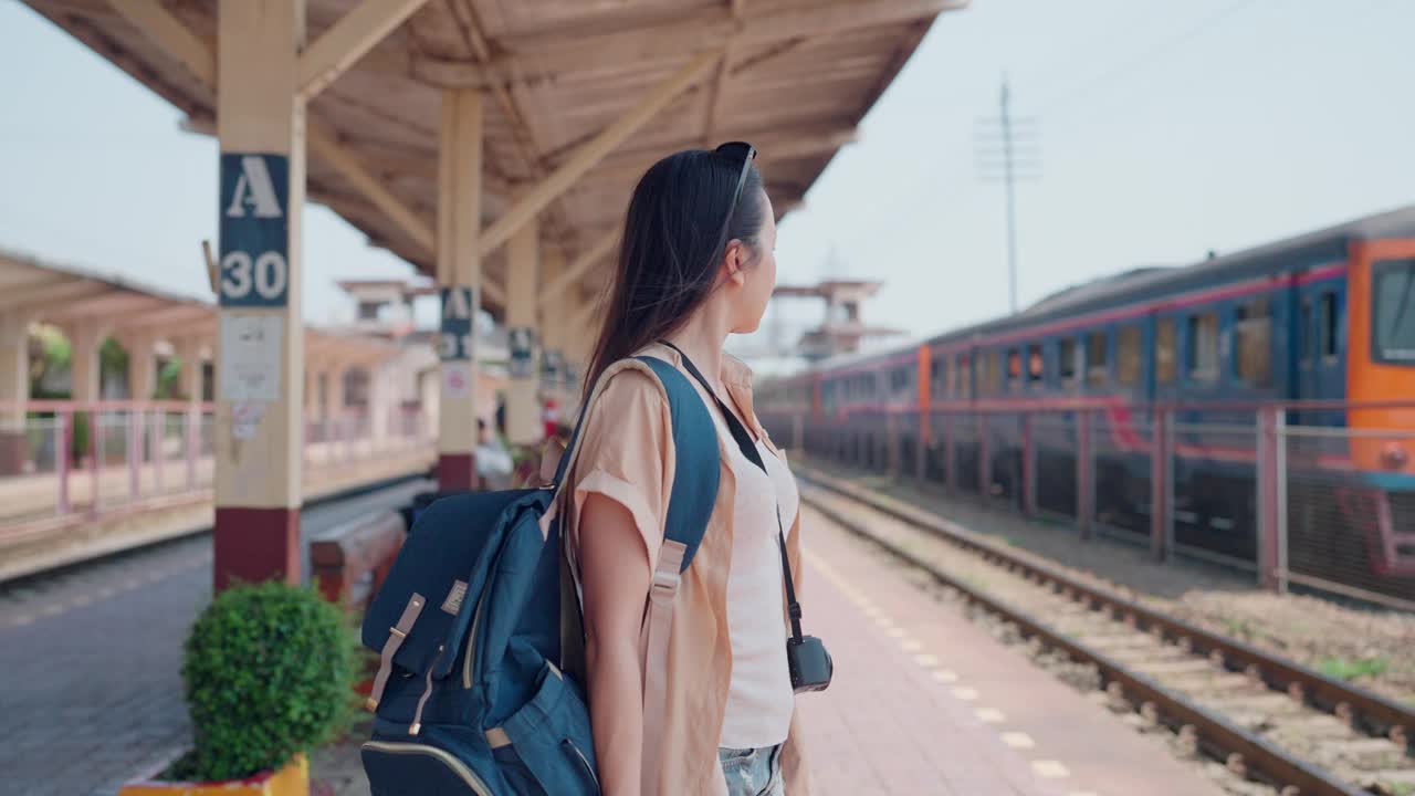 从后面看到的一个旅行者，凝视着远处的火车站台视频下载