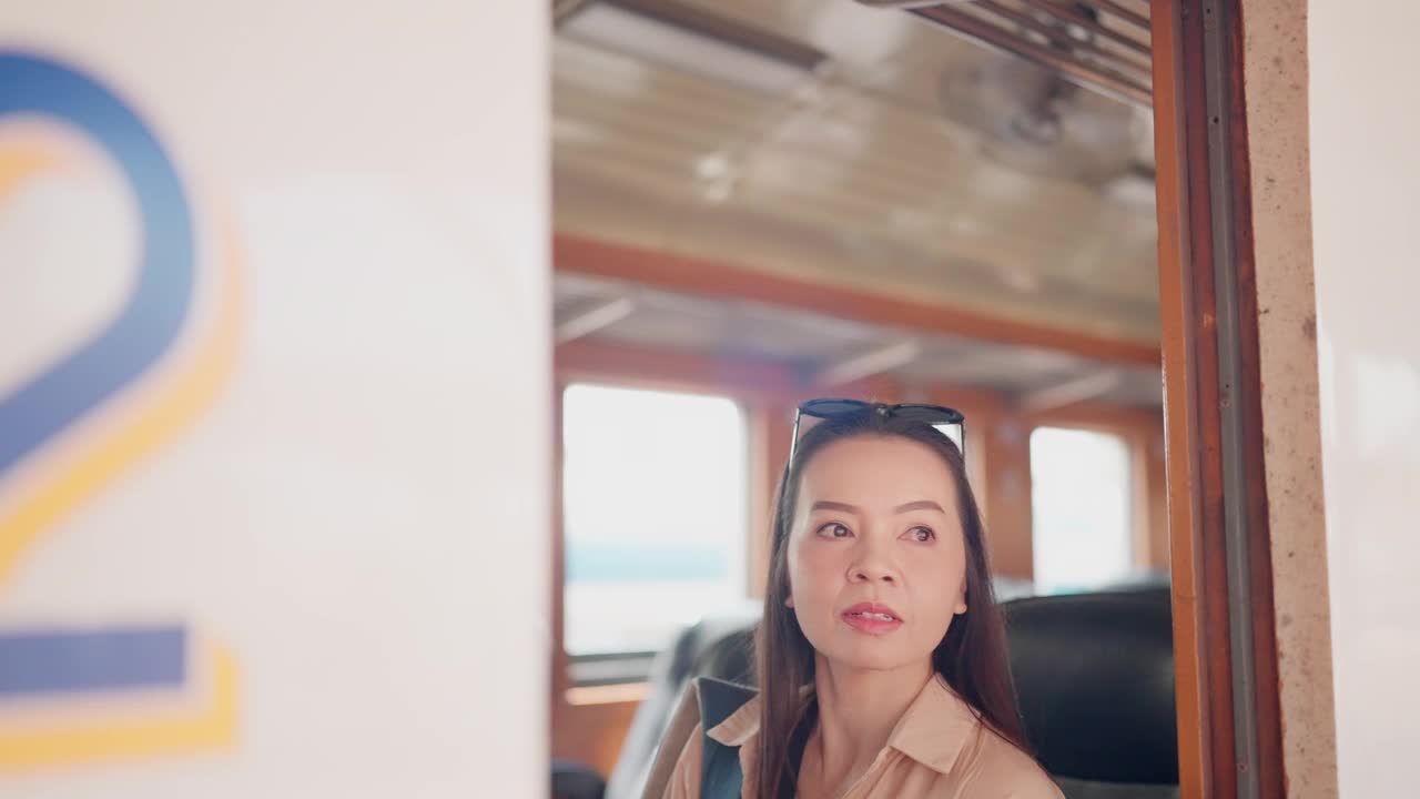 一名女子在火车上若有所思地望着窗外，也许在思考她的目的地或旅程。视频下载