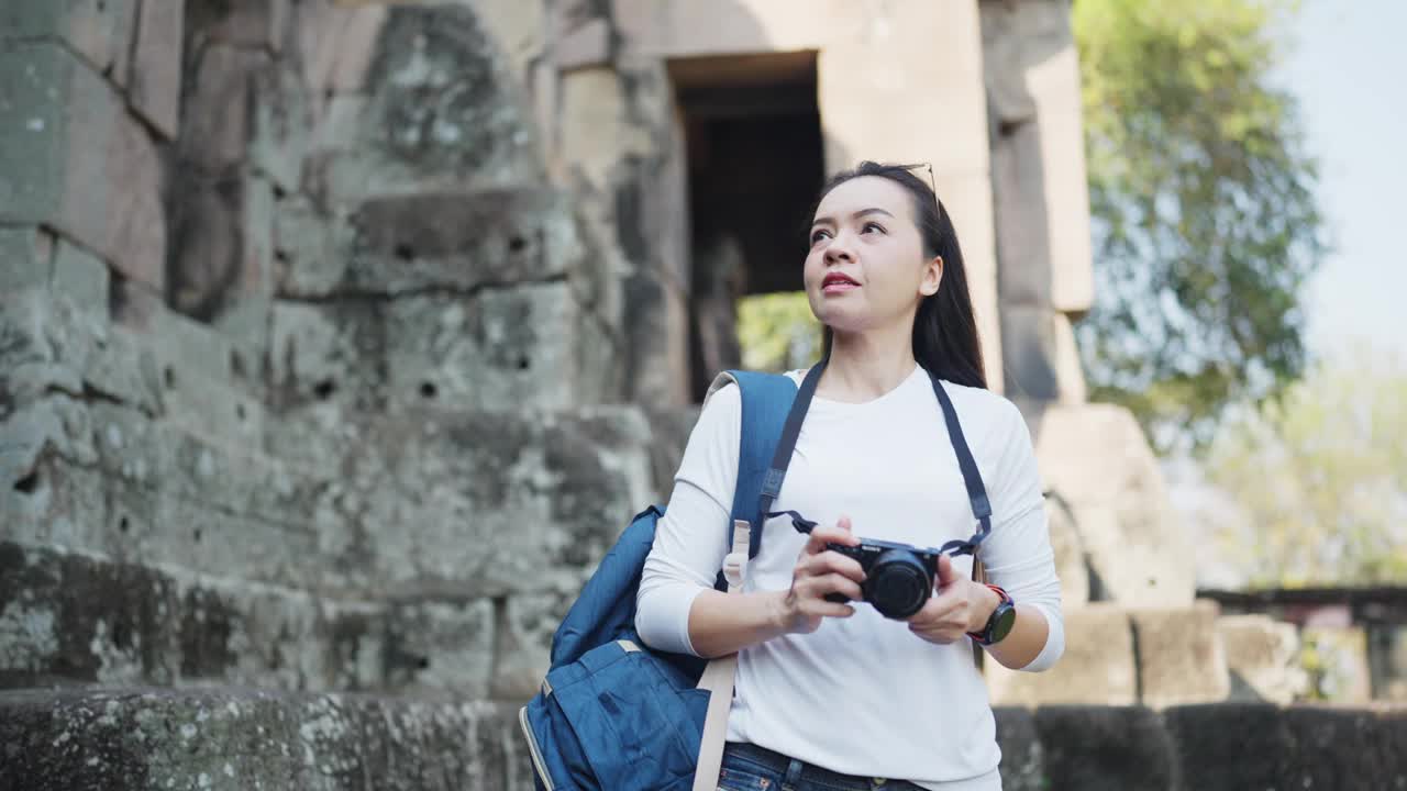 一个微笑的女旅行者背着背包拍照视频素材