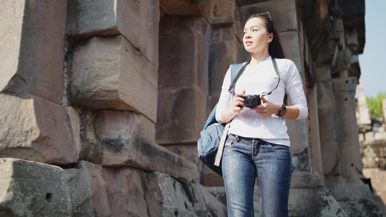 一个微笑的女旅行者背着背包拍照视频下载