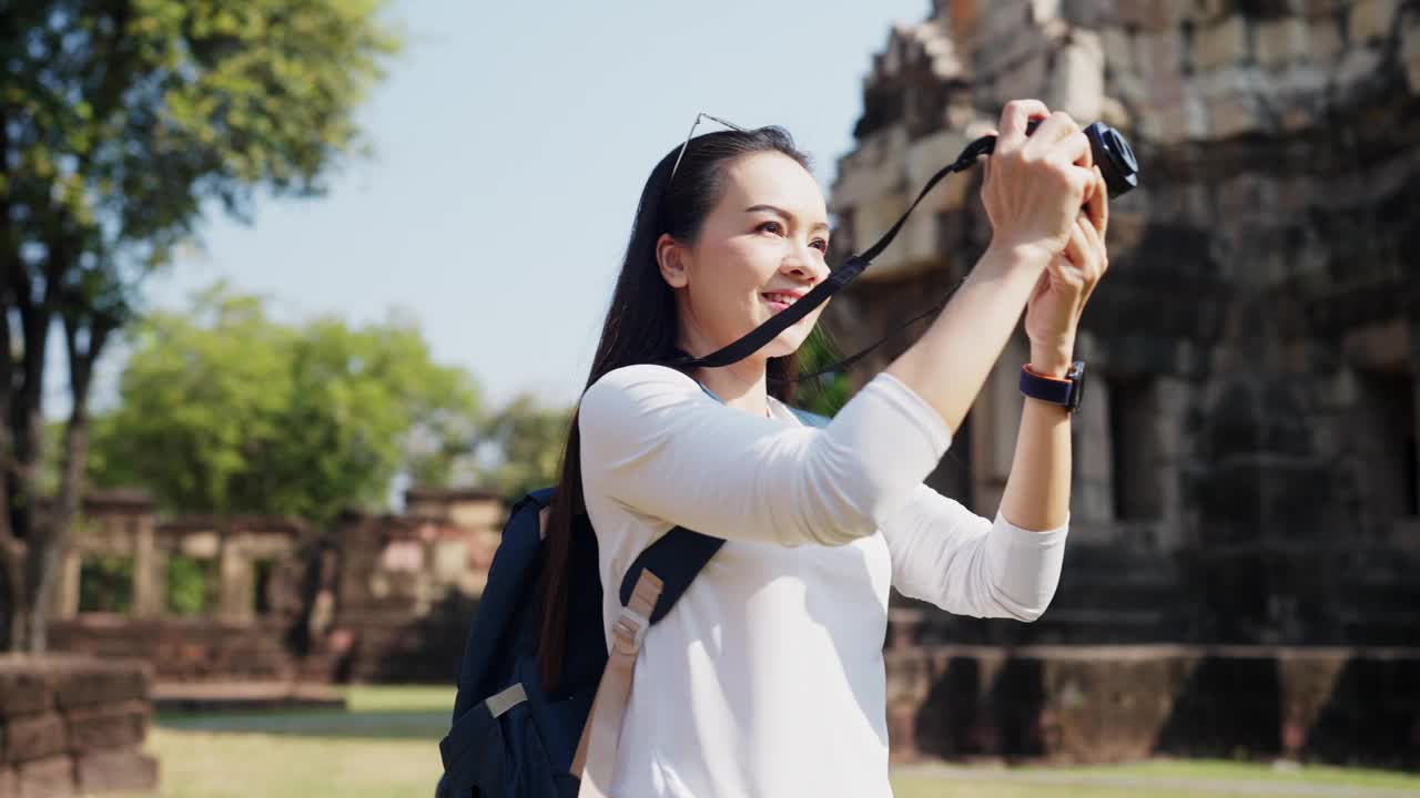 一个微笑的女旅行者背着背包拍照视频素材