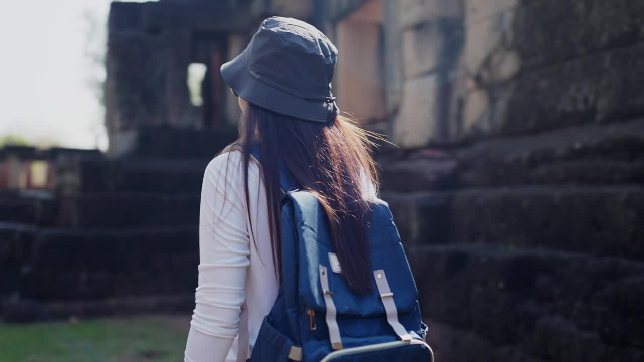 背着背包的年轻女子站在城市里，视频下载