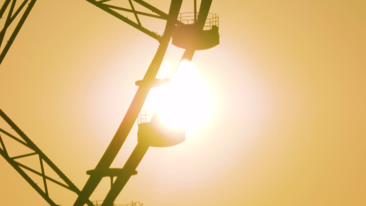 摩天轮的剪影在夕阳的映衬下旋转视频下载