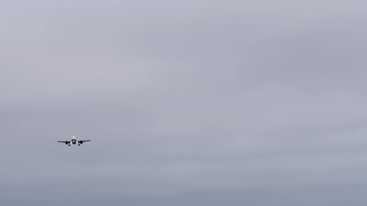 客机、客机的剪影在灰色的天空中飞舞视频下载