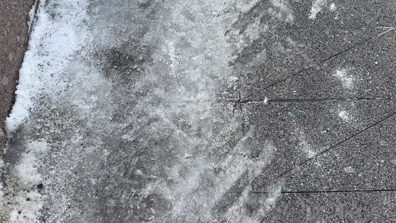 冬季路面上的除冰化学品。结冰的人行道铺路板上的盐粒视频下载
