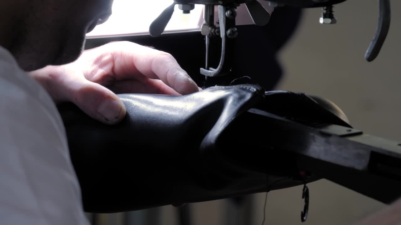 鞋匠使用缝纫机和修补皮革女鞋-近距离视频下载