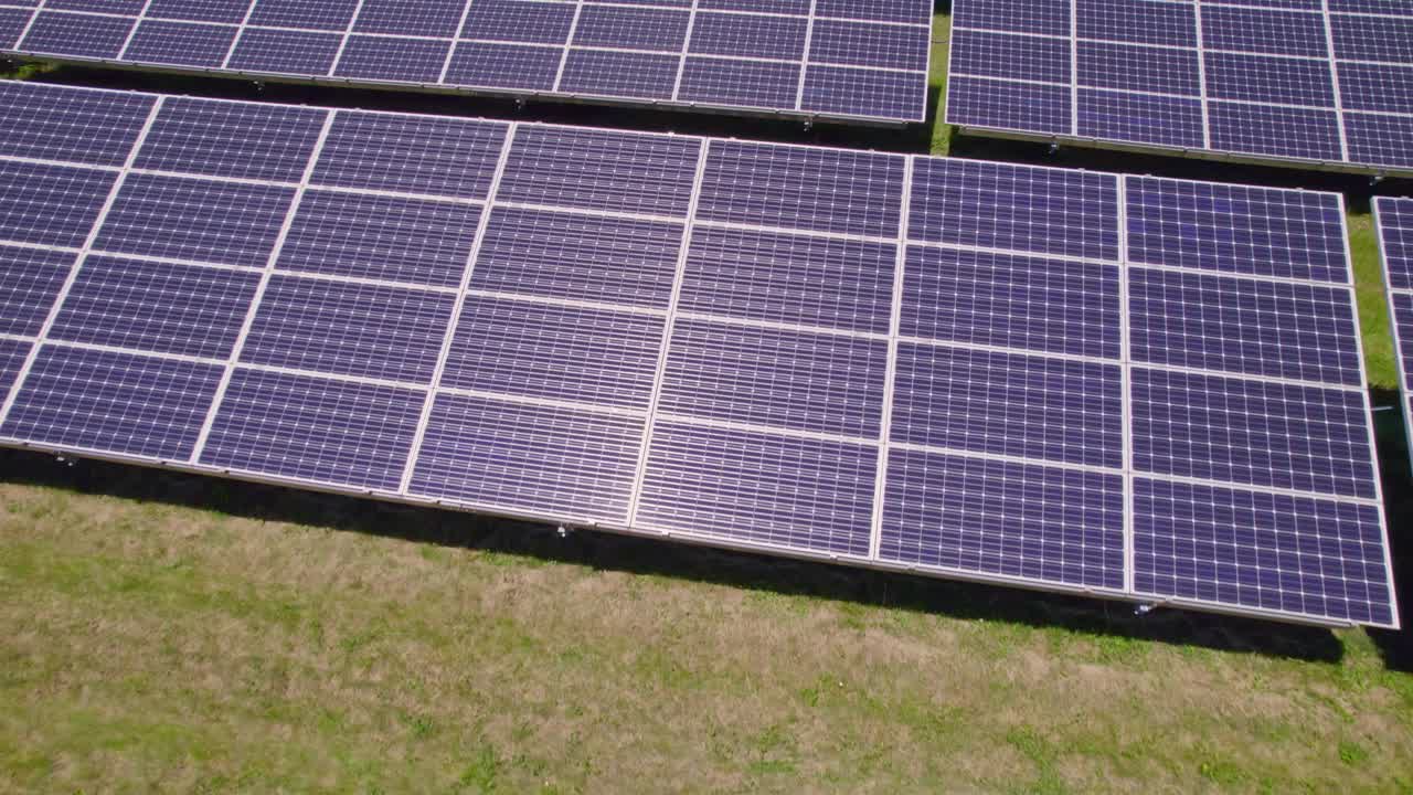太阳能电池板农场鸟瞰图。现场用太阳能电池进行绿色能源发电。对自然环境无害的现代创新电力农场的俯视图。视频下载